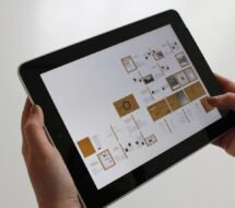 Close-up of hands using a tablet, displaying a digital interface.